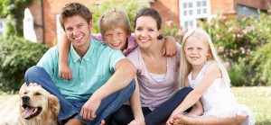 Family Sitting In Garden Together